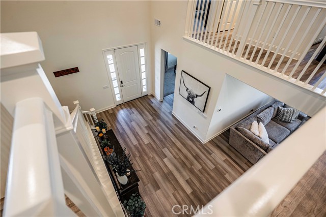 Picture was taken from the upstairs looking down to the front door entrance. Soaring ceiling makes this space so oppulant! You can see the front door, downstairs side right door to enter into the first downstairs en-suite bedroom/bath. Cozy front entry way and family room to the bottom right of photo.