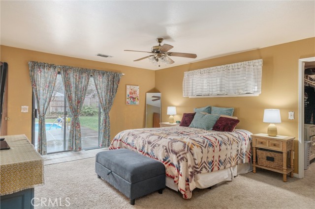 Primary bedroom with sliding glass doors to patio and pool.