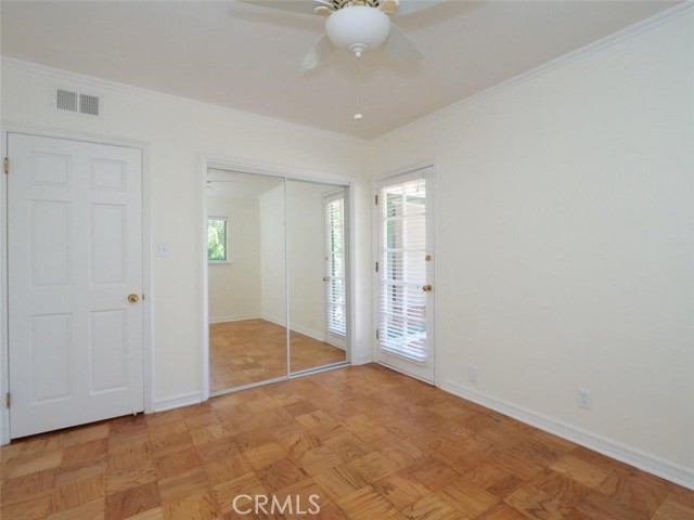 Bedroom 4/office with ceiling fan, refinished floors and fresh paint and easy egress to the patio.