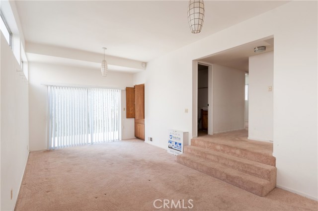 This picture was taken in the family room looking towards sliding doors to backyard. Stairs lead to bathroom and 2 bedrooms on this lower level of the home. The sliders open to sunny patio and nice backyard.