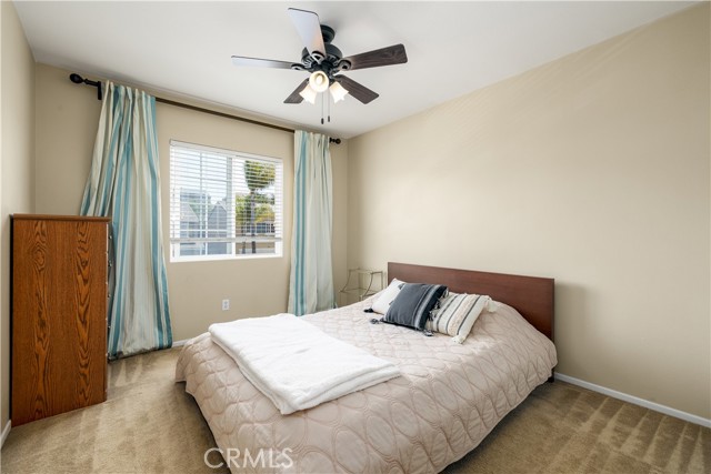 Upstairs secondary bedroom with ceiling fan.