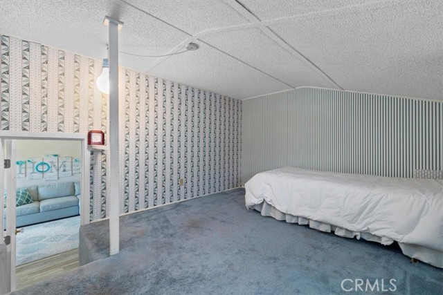 This room is not included in the house's square footage. It is perfect for storage, extra bedroom perhaps or study/den. It is over the garage and accessed from the living room/entry area. You can see the living room through the doorway.