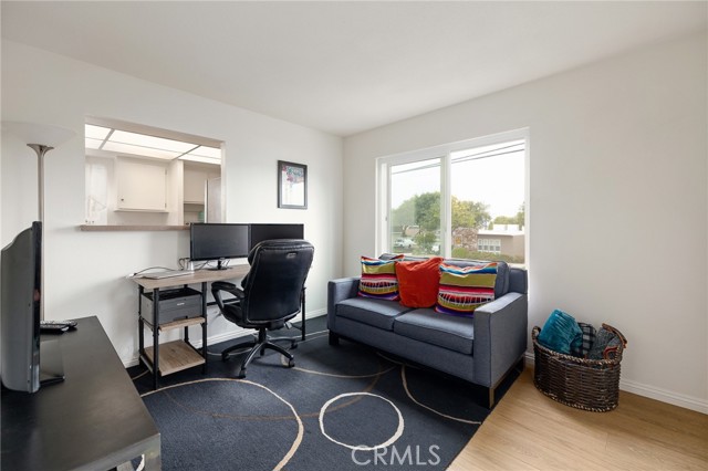 Home office with window into kitchen, big windows and balcony (off camera to the right)