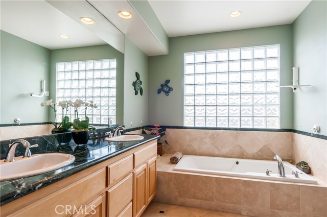 His and hers dual sinks in the bright master bath.  Glass block wall provides light and privacy.