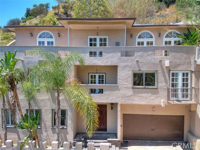 6075 Rodgerton Drive Los Angeles, California Custom Hollywood Hills Tri-Level Hillside Home, Mediterranean Architecture w/Million Dollar Views. Beautiful hardscape, 3BR+5BA, plus Office/Den (could be 4th bedroom) 4,259 SF on 9,975 SF Lot, Beautiful Hardwood and Tile Flooring throughout, Earth tone Paint, Solid Panel Doors, Courtyards, French Doors w/Arch Windows and Large Balcony. Private suite bedrooms with own bathrooms, formal office/den with wet bar & full bathroom. Gorgeous open kitchen with large center island with cook top, Quartz counter tops, Stainless Steel Appliances and Stunning View. Mid level private courtyard with relaxing Spa, upper level courtyard area with in ground fireplace, water feature, roof top sitting area with stunning view.