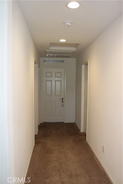 Hallway upstairs leading to room and laundry area