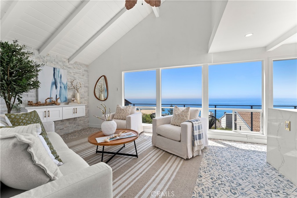 Captivating Panoramic Ocean Views gracing the coastline, extending towards Catalina Island, define this distinguished property nestled in the heart of Laguna Beach. Offering ocean vistas from every room, this recently renovated residence boasts modern enhancements and a color scheme that harmonizes with the coastal ambiance. Situated on a tranquil cul-de-sac just off Alta Vista, this home enjoys a coveted location within walking distance of Laguna Beach, adjacent to PCH, and mere minutes from upscale dining establishments, including the renowned Victoria Beach. Upon approach, the home's remarkable curb appeal is immediately evident, characterized by a paver-laid driveway that winds around the lower-level lounge area, vibrant landscaping, refined stucco finishes, and ornate flooring tiles leading to the main level. The expansive wrap-around Trex decking, recently upgraded and adorned with brand-new wrought iron railing, offers unparalleled 180-degree ocean views from various vantage points, including bistro seating, an oceanfront area, and a lounge space with southeast-facing vistas. Stepping through the custom solid white oak door, oversized picture windows greet you with sweeping views of the Pacific Ocean. The main level features a meticulously designed living room boasting custom flooring, a striking stacked stone accent wall with floating built-in storage. The focal point of the interior is the impeccably renovated custom kitchen, featuring quartz countertops, peninsula seating illuminated by modern globe pendant lighting, white shaker cabinets with gold hardware, stainless steel appliances, recessed lighting, a farmhouse sink with a gold gooseneck faucet, stack stone backsplash, and ample storage. Ascending to the upper level reveals the primary suite, complete with custom built-in storage, bedside pendant lighting, recessed lighting, and a fully renovated en-suite bathroom featuring a quartz-topped vanity, modern fixtures, scallop backsplash, recessed lighting, and a vanity mirror with built-in illumination. The lower level encompasses the second bedroom, complemented by a compact kitchenette area, a full bathroom, and the home's laundry facilities with full-size side-by-side washer and dryer. For those envisioning a beach-centric lifestyle in a home offering unparalleled ocean panoramas, this property beckons with open arms – WELCOME HOME.