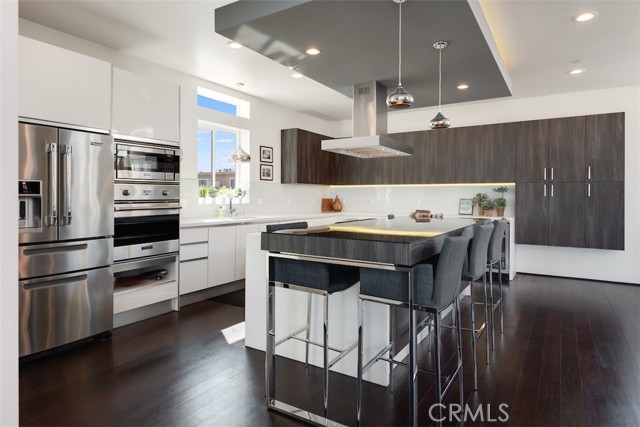 The kitchen has a large center island with lots of counter top space and loads of cabinets.