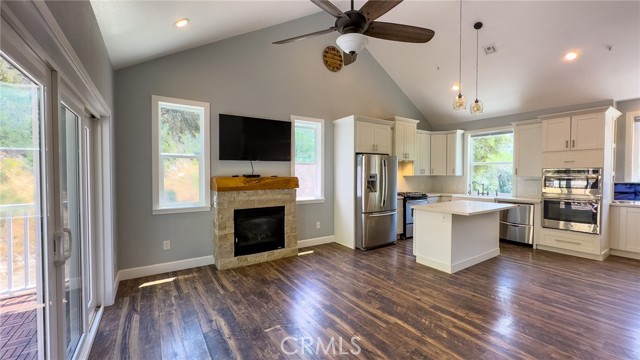STEP INSIDE: NOTE THE VAULTED CEILINGS, FIREPLACE & CEILING FAN.