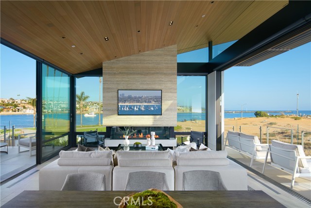 Discover an intimate living experience in harmony with the sand and sea at The Wedge House: a brand-new (2022) decadent-masterpiece flawlessly designed as an entertainer's paradise. Set on two oceanfront lots (2168 & 2172) at the end of the Balboa Peninsula, this trophy estate occupies one of the largest oceanfront homesites in coastal Orange County with a combined view frontage of appx. 140-feet. Overlooking the legendary Wedge surf break, with unbroken ocean, whitewater, beach, channel, China Cove, park, and shimmering city-light vistas, the exquisite four-bedroom, three-and-one-half-bathroom residence’s smooth contemporary style reflects the efforts of revered GRAHAM Architecture and premier custom home builder Chris Gallo of Gallo Builders. A double-height foyer and custom pivoting door present the stunning interiors of appx. 3,725 SF and introduce the lower level dedicated to an office with outdoor access, an after-beach changing room with shower, and a magnificent beachfront primary suite with two walk-in closets, high-end spa-caliber bath featuring a freestanding tub and rain shower, and two sets of glass pocket doors that open to an oceanfront patio complimented by panoramic views and an open-air fireplace. Ascend to the main level by the Elevator Boutique elevator or wide custom staircase with 1"-thick glass stair rails, and find three additional bedrooms and two-and-one-half bathrooms. Floor-to-ceiling walls of glass in the living and dining areas create an on-the-water effect enhanced by slide-away glass pocket doors that open to a fireplace-warmed ocean-view deck. Vaulted hemlock wood ceilings lend architectural drama to the space and flow seamlessly onto a water-view courtyard with an outdoor kitchenette, and a sleek, modern kitchen showcasing custom cabinetry from Germany and top-tier Gaggenau appliances. A residence of this distinction deserves only the finest, and it impresses with hydronic radiant-heated floors throughout, Italian porcelain tile and white oak wood flooring, low-maintenance Caesarstone quartz countertops, Fleetwood doors and windows, Sonos speakers, J. Geiger automatic window shades, rift white oak interior doors, and a Savant whole-house smart-home system. A rare offering of two exclusive addresses, this landmark estate also comes with city and coastal development approved plans for a one-bedroom, one-bathroom guest house with a kitchen, courtyard, two-car garage, pool, and spa.