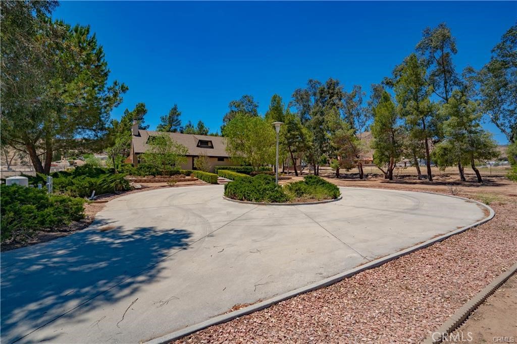 Custom built home in the heart of Ague Dulce. Single story 3 bedroom home on 4 usable acres. Open floor-plan with real wood-burning fireplace w/ heatilator, hardwood floors, and a mudroom/laundry room with 3/4 bathroom off kitchen leading to the attached 2 car garage. Home has upgraded dual pane, wood cased Anderson windows, LED lighting, large 4 foot entry and back doors, a 1 year old roof, R16 insulation under raised foundation, R30 above ceiling and bonus storage space above house and garage. The primary bedroom has a private bathroom with double sinks and dressing/make up counter. The property features a large circular driveway, 40 plus year old trees and 30 plus year old plants and landscaping. Outback is an attached large storage shed and plenty of room for RV parking or horse facilities. This property has paved road access, 2 working wells, natural gas service, and the rear of the property has a lower section with road access.