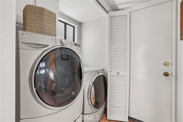 The laundry closet with washer and dryer. The door is to the attached two car garage.