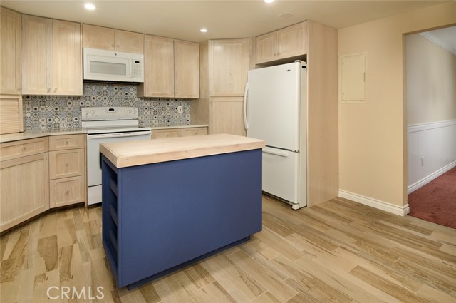 Wood-look tile, newer cabinets, countertop, recessed lighting.