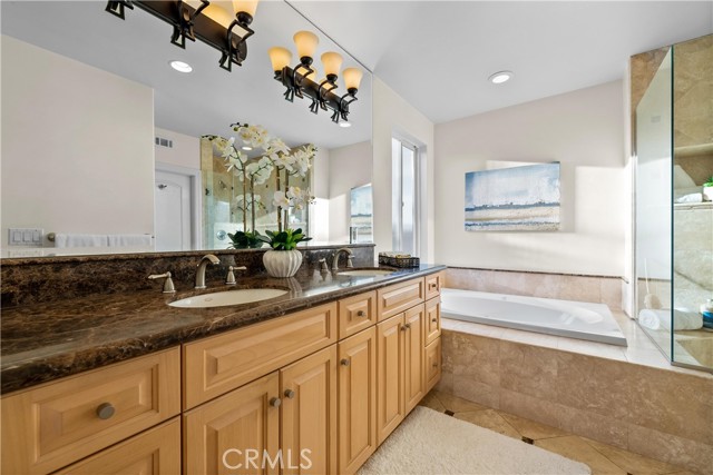 Primary bathroom with soaking tub and marble counter tops