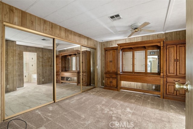 Primary Bedroom with large closet and built-in cabinets and headboard.