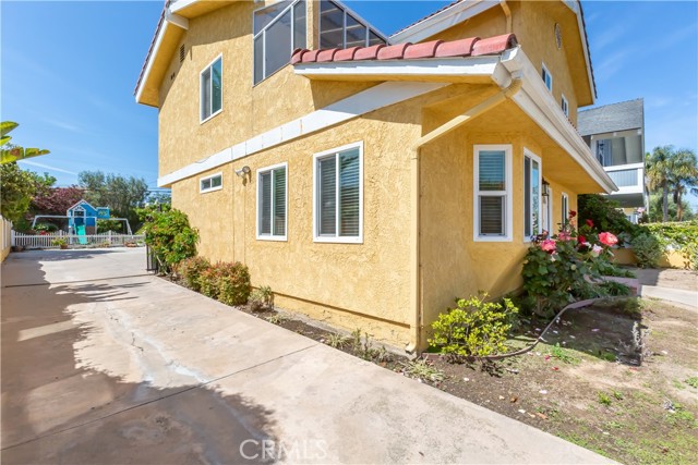 East side of home with massive driveway to garage and backyard