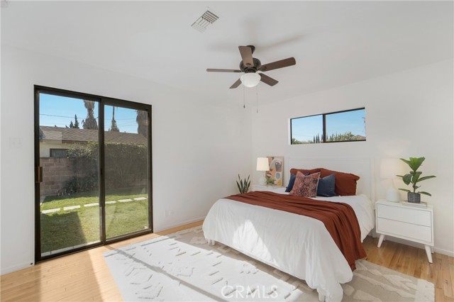 Primary suite with view to the grassy yard & covered patio.