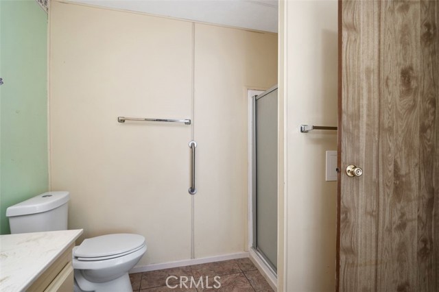 Secondary bathroom features walk-in shower and safety grab bar. The bathroom is Jack-n-Jill style with an entrance from the secondary bedroom and the hallway for guests.