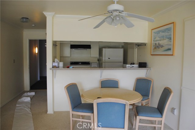 Dining area with lighted ceiling fan and pass through with granite counter.  Lighted ceiling fan.