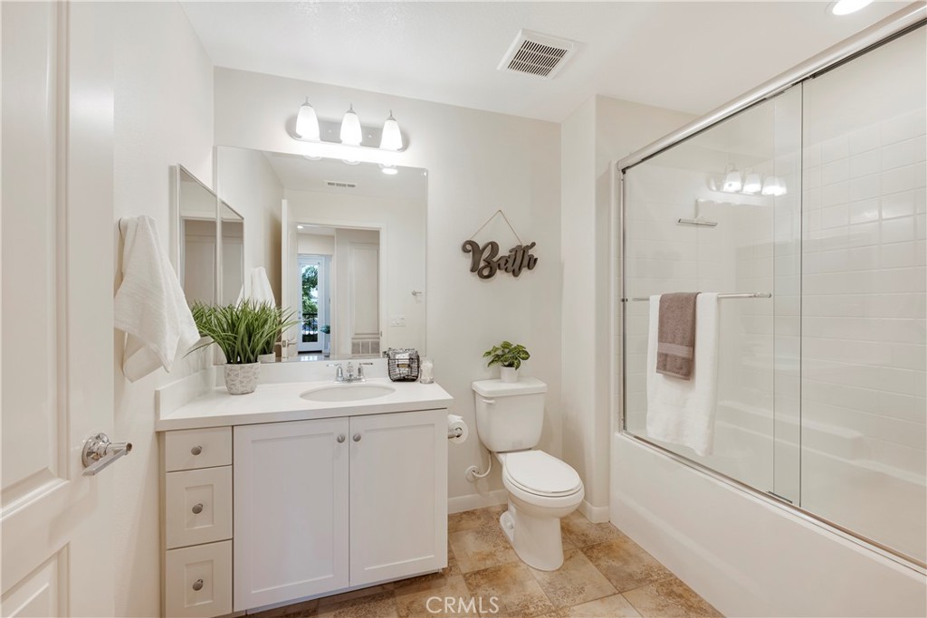 Bathroom #2 is located off the hallway and has White Cabinetry, Large Tub/Shower with Sliding Glass Door Enclosure, and Tile Flooring!