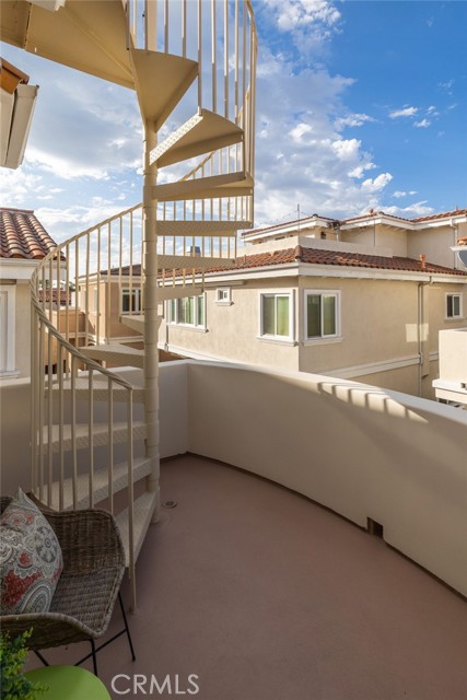 Deck off living area with stairs to rooftop deck.