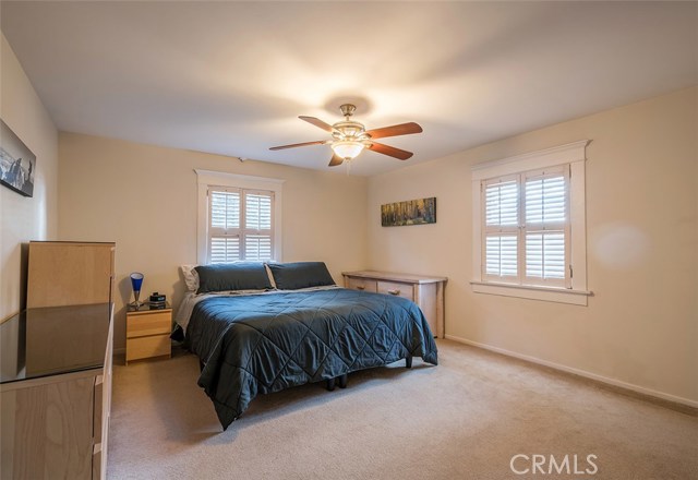 Current master bedroom with windows to the front and side of the home. The master bedroom features a walk-in closet and new ceiling fan.