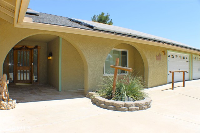 Spanish Arches, a Custom Front Door and Covered Front Porch add to the charm of this Hacienda.