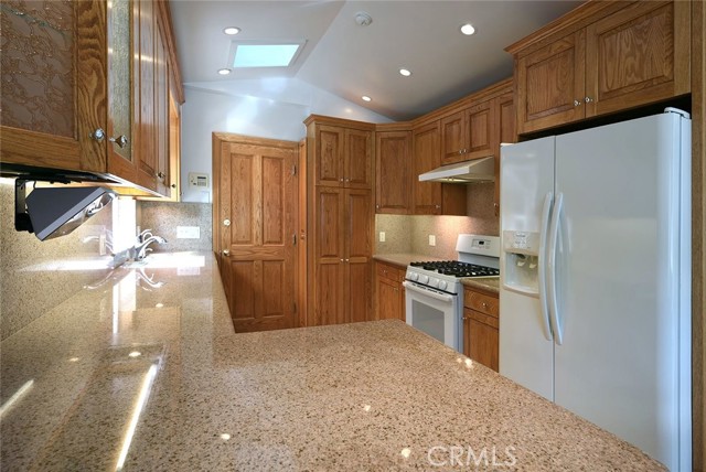 Amazon-direct monitor on a swivel bracket; red-oak cabinetry throughout; dimmable mood lighting