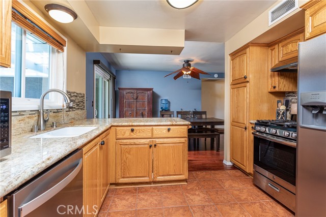 28209 Hot Springs, Kitchen opens to dining; newer stainless steel appliances; tile floor, granite counters; sink overlooks the pool and patio.