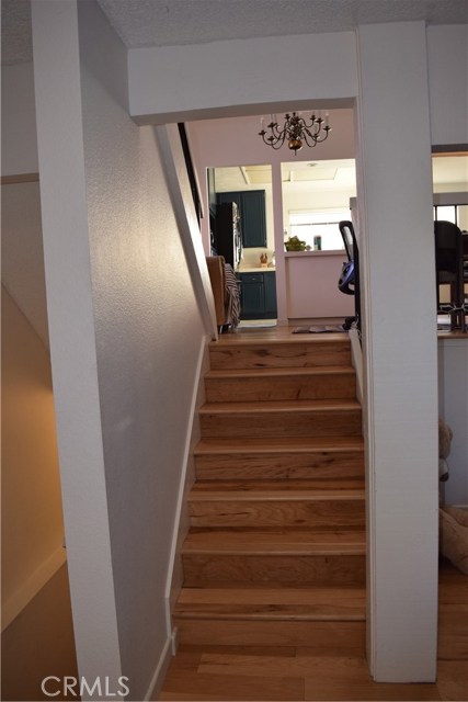 Stairs from living room/entry hall to kitchen/dining and first bedroom level.