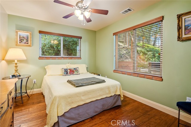 At the end of the hallway past the kitchen and main bathroom we find the guest bedroom.  It connects to the main bathroom and has engineered hardwood floors.