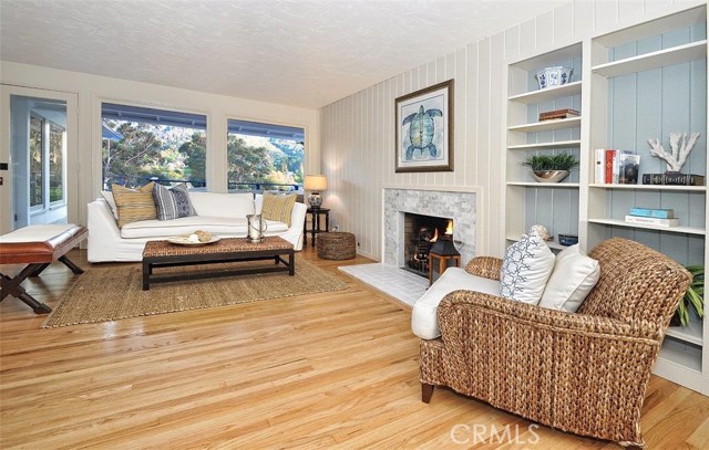 Beautiful living room with hardwood floors and marble fireplace.