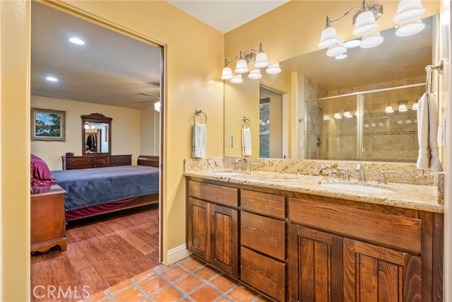 The ensuite bathroom features a double sink vanity with granite countertop, Saltillo tile floors and a solar tube to bring in natural light.