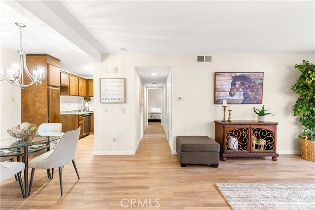 View of dining room, hallway and partial living room. Open floor plan featuring smooth ceilings, new paint, new flooring and great end unit location.