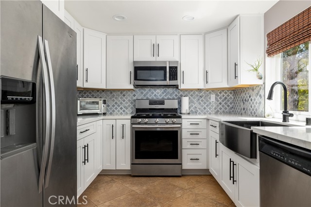 Remodeled kitchen with stainless steel appliances and recessed lighting.