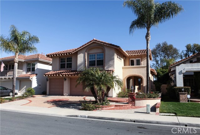 26322 Ibeza Road Mission Viejo, California A study in style & grace, this immaculately upgraded 4-bedroom home was designed to maximize views of the distant mountains & city lights. Floor to ceiling windows allow for natural light to radiate throughout the formal living & dining spaces, while providing an unparalleled backdrop. Elegant laminate floors, crystal chandeliers, vaulted beamed ceilings & the extensive use of stone and glass are just some of the refined accessories used throughout the home. The gourmet kitchen boasts a center island, cozy breakfast nook with views of the outside, newer stainless steel appliances: Refrigerator, double oven, built-in microwave, dishwasher, & a gas cooktop. The adjacent family room offers a fireplace & upgraded wet bar with glass shelves, granite counters & added storage cabinets. The main floor bedroom with en suite is great for guests/in-laws. The private, second level master suite enjoys mountain views, a fireplace, upgraded bathroom with dual sinks, Roman tub and separate shower. The second level also includes a bonus room with Plantation shutters, as well as, the remaining two spacious bedrooms. A low maintenance yard with covered patio area offers plenty of room to enjoy outdoor activities. Additional amenities: 3 car garage with remotes, including Tesla charging station, window coverings, recessed lighting & neutral paint throughout. The home is close to award winning Bathgate elementary & has Lake Mission Viejo privileges.