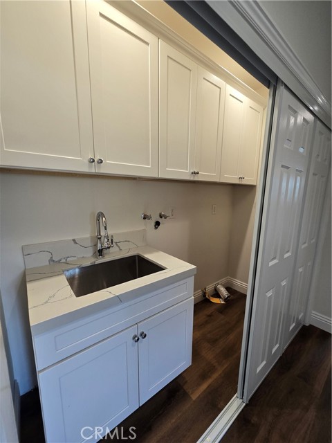 Centrally placed laundry area with sink and storage.