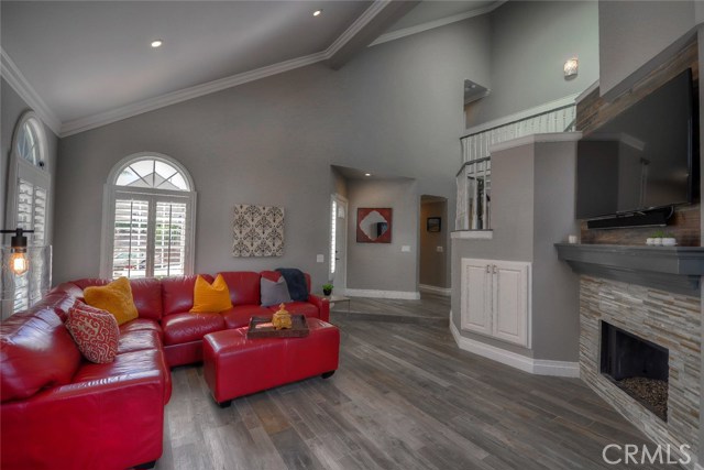 View into the family room toward the front door with the TV mounted above the fireplace.