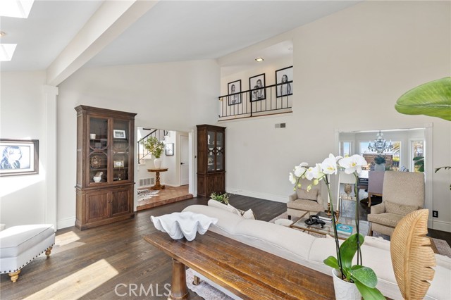 The formal living room with soaring vaulted ceilings, a romantic custom fireplace, and wide plank French oak floors.