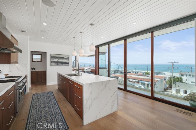 Beautiful, gourmet kitchen with gorgeous porcelain waterfall island counter, then pantry and nook looking South