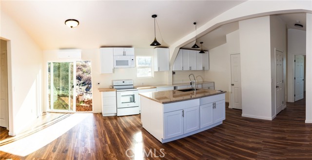 15367 Summit Boulevard Cobb, California Brand New Custom Built Home in the heart of Cobb! This 3 bed / 2 bath with 1,404 SF home has all the bells and whistles you have been looking for! Enter to find a spacious and open floorplan with vaulted ceilings & custom arches throughout adding character and charm. Lots of windows and bright light radiate from the main living space. The open concept kitchen includes an island with Granite countertop + breakfast bar. Quartz & butcher block countertops at the back of the kitchen, New electric range & microwave + loads of storage in the self closing cabinetry/drawers & a walk-in pantry! Durable wood laminate flooring throughout. Indoor laundry is a bonus! The desirable separation floorplan is sure to please! 2 bedrooms and hall bathroom on one side of the home with master on the other. The spacious master suite offers an oversized walk-in closet & ensuite bathroom has a dual sink vanity with granite countertops & tub/shower with beautiful tile surrounding. On demand water heater and energy efficient zoned mini-splits (4) throughout. The landscape is a blank canvas for you to paint however you desire! Located on a gently sloping corner parcel with plenty of room for parking or recreational vehicle storage. Nearby, find modern conveniences such as golf courses, community pools, grocery store, coffee shop, restaurants & more! This AFFORDABLE, highly efficient, firewise home is one not to be missed!