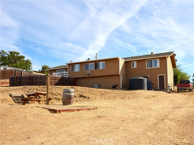Rear view of home, easy access under the house, 2500 gallon water storage with booster pump