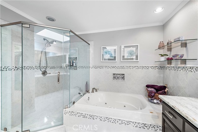 Upgraded tile in the glass surround shower and soaking tub.