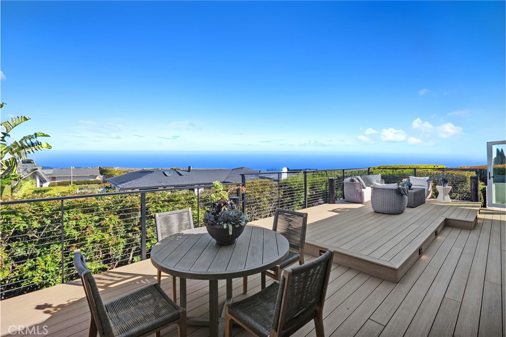 Panoramic ocean views, beautifully remodeled contemporary design, and a private location with an extended driveway set the stage for Vista Soltierra Azul—an exceptional single-level residence in the prestigious Monarch Bay Terrace. Every detail of this spacious coastal sanctuary has been thoughtfully curated to offer the perfect blend of refined style and effortless California living. A dramatic Rift-cut white oak pivot door opens to light-filled interiors wrapped in wide-plank French oak flooring, gallery-height ceilings, and smooth Venetian-finished walls. Expansive folding glass doors frame stunning ocean views and seamlessly connect the main living areas to a generously scaled ocean-view terrace with custom Timber Tech decking—perfect for entertaining. The chef’s kitchen impresses both aesthetically and functionally, with sweeping ocean views, a 10-foot Taj Mahal quartzite island, and custom rift-cut cabinetry with glass panel accents. Culinary-grade appliances include a True commercial refrigerator, Thermador professional range, Miele built-in coffee station, Miele dishwasher, Vinotemp wine dispenser, and Thor beverage center with sink and ice maker. Thoughtful touches like a solid brass faucet, designer pendant lighting, and seamless quartzite backsplash complete the space. The expansive primary suite features panoramic ocean views, a private outdoor lounge, custom walk-in closet, and a spa-inspired bath with Namibia Mystery Blue marble, dual vanities, a sculptural soaking tub, and oversized rain shower. A separate casita/ADU offers a private entrance, spa-style bath, and secluded patio—ideal for guests, multigenerational living, or a creative flex space. Two additional bedrooms share a designer Jack & Jill bath with custom vanities, gold hardware, and stone slab surrounds. Outdoors, the property is designed for elegant entertaining, with panoramic views, a custom ocean-facing deck, and lush privacy landscaping. The finished 3 car garage was designed with the car enthusiast in mind, features glass-panel doors, marble-look epoxy floors, LED ceiling lights, custom built-ins, and a large inlaid TV for the ultimate functional showroom. Vista Soltierra Azul captures the essence of California coastal living—where panoramic ocean views, seamless indoor-outdoor spaces, and refined design come together in perfect harmony. From sunrise to sunset, this is a home that captures the spirit of the coast and elevates everyday life to something truly extraordinary.