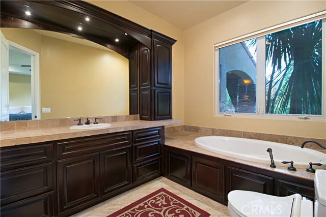 Downstairs suite bathroom features a spa like bathtub, and vanity area.