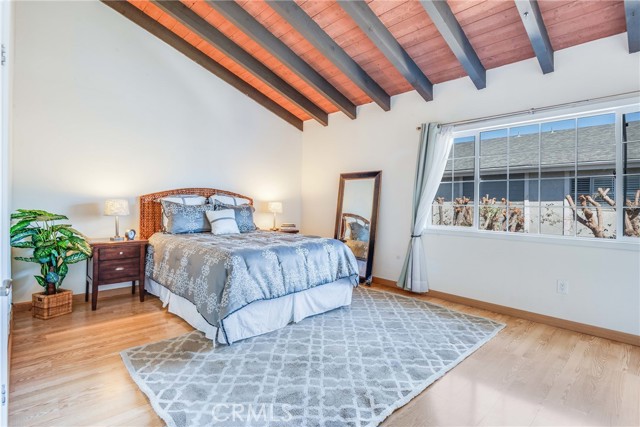 Spacious primary suite with vaulted wood beamed ceilings is a tranquil retreat