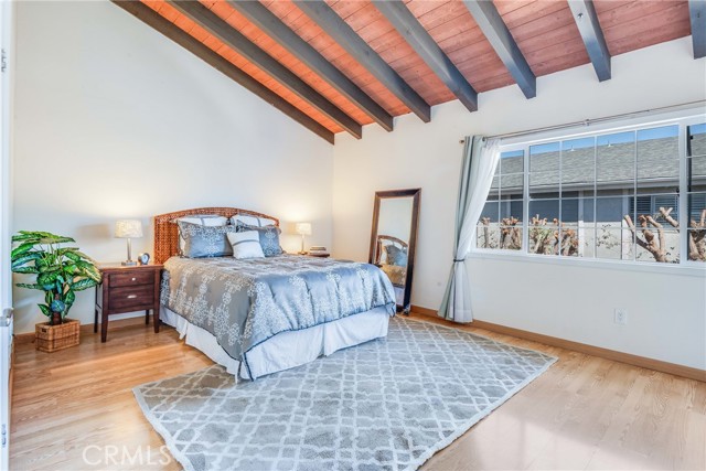 Spacious primary suite with vaulted wood beamed ceilings is a tranquil retreat