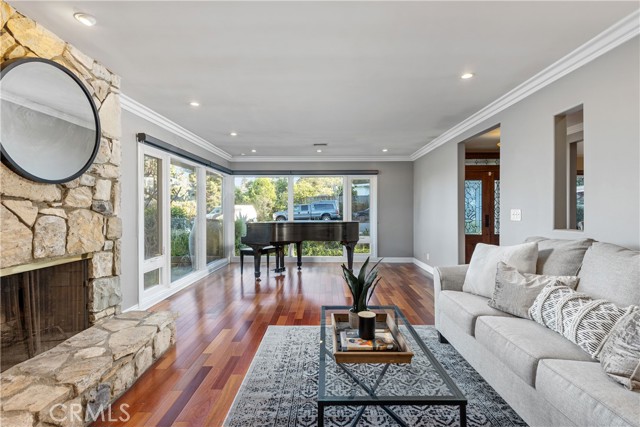 The formal living room with tall picture windows that overlook the surroundings bring in abundant natural light.