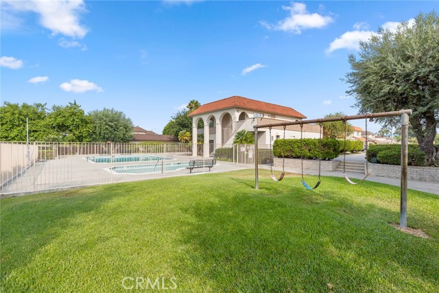 Grassy community area with views of the clubhouse and sparkling pool and playground.