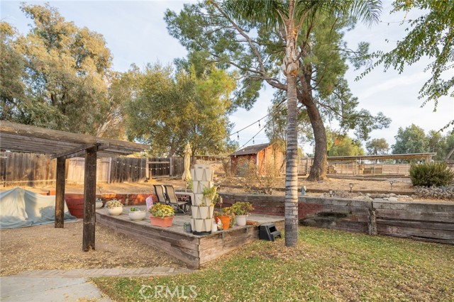 BACKYARD PATIO AND DECK IS SURROUNDED BY MATURE TREES FOR NATURAL SHADE.